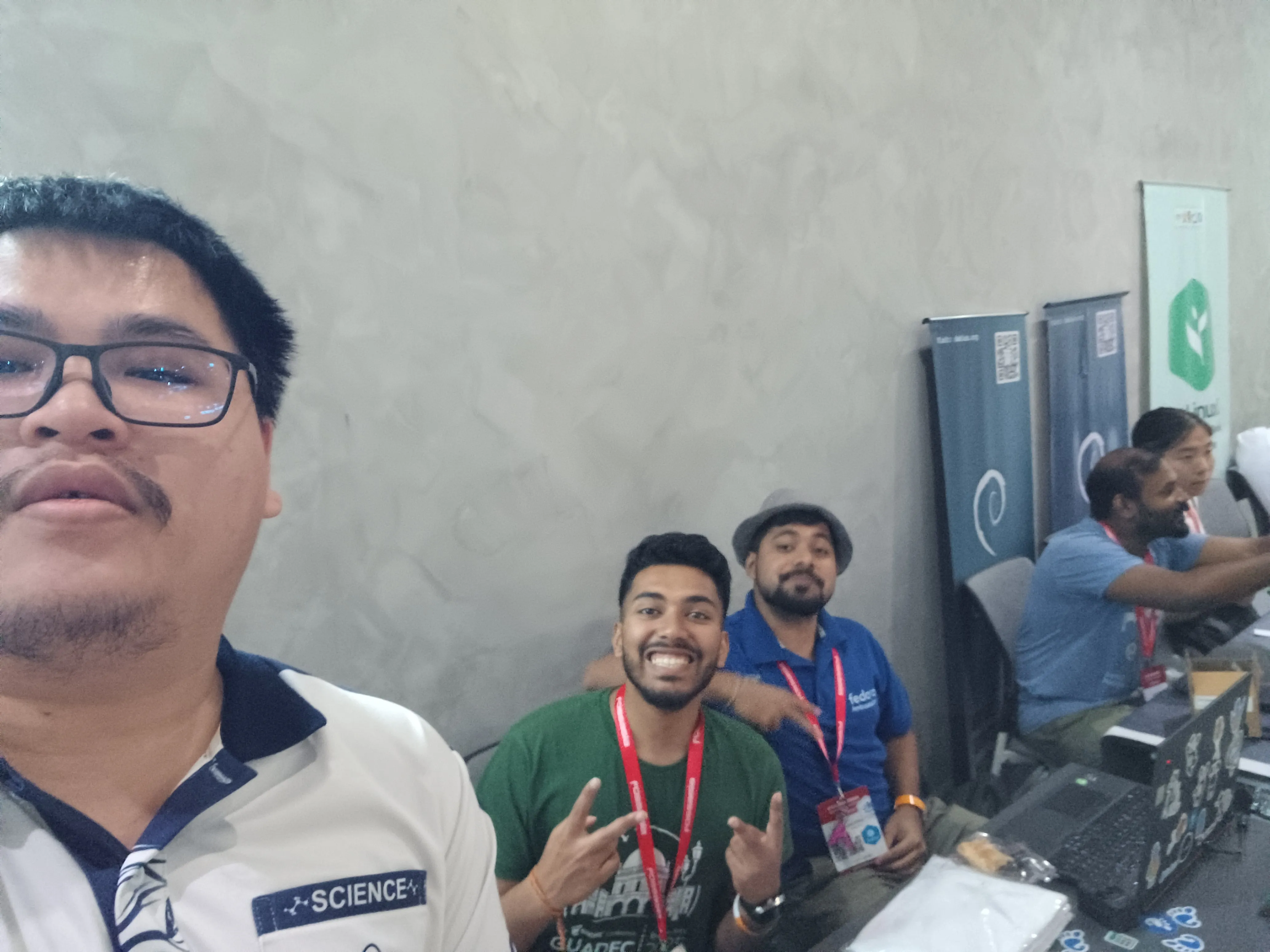 A selfie of me and the people at the GNOME booth, with me being slightly out of frame and looking too high up because of my horrid selfie skills